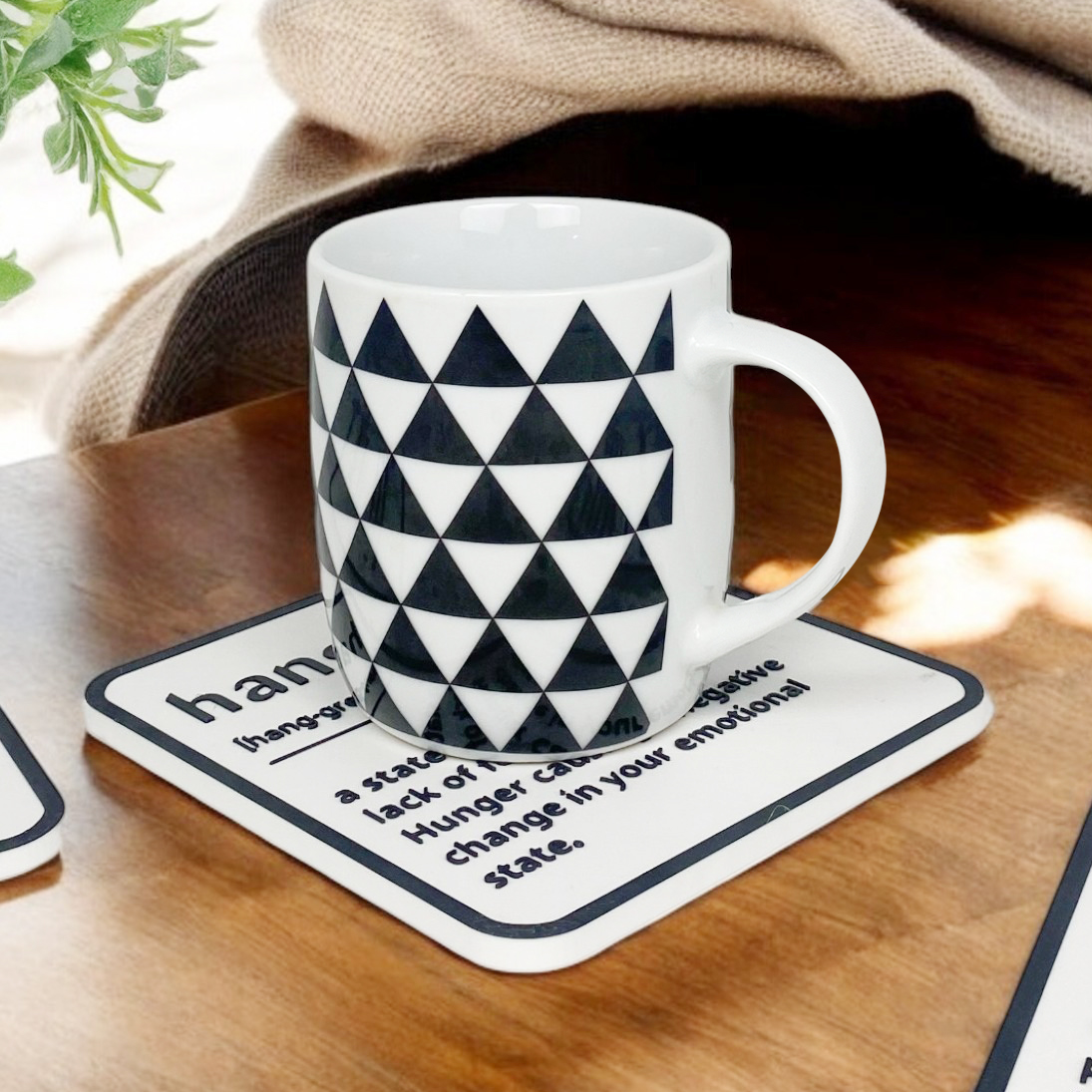 A black and white coaster with personalised name and description on the coaster.