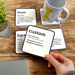 A black and white coaster with personalised name and description on the coaster.