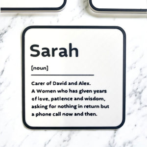 A black and white coaster with personalised name and description on the coaster.