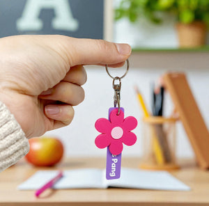 Colourful flower-shaped keychains with personalised name tags.