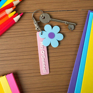 Colourful flower-shaped keychains with personalised name tags.