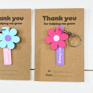 Colourful flower-shaped keychains with personalised name tags.