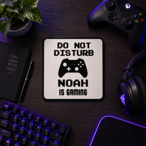 Personalised gaming sign reading NOAH IS GAMING laid flat on a desk with keyboard and headset