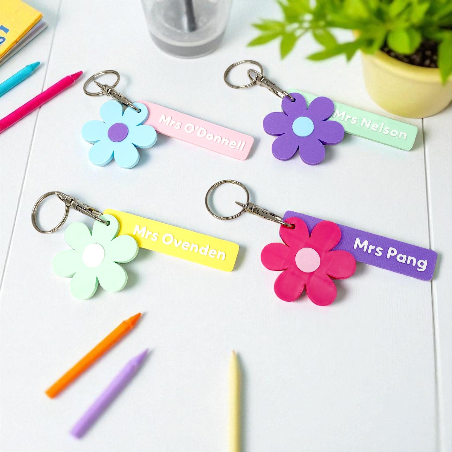 Colourful flower-shaped keychains with personalised name tags.