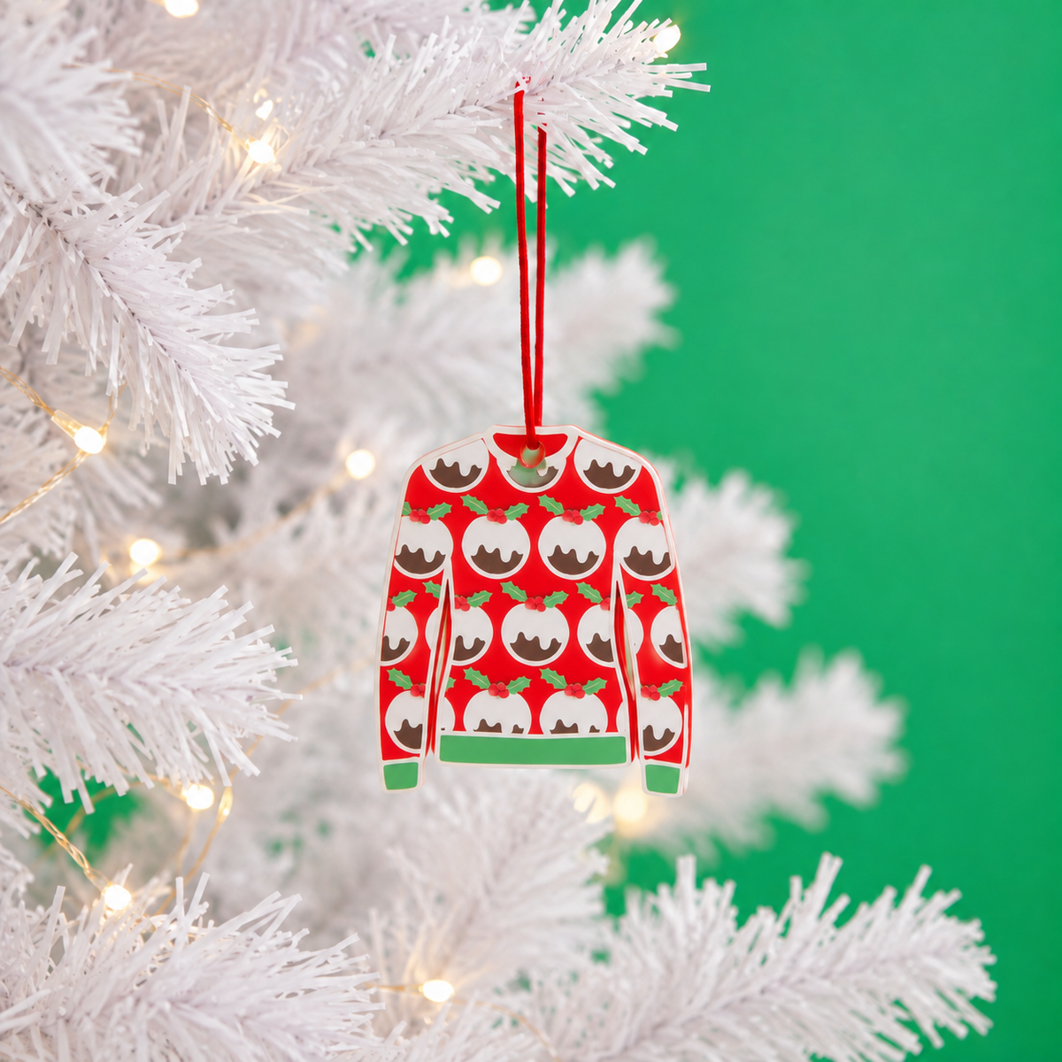 Christmas Pudding jumper decoration hanging on a white tree