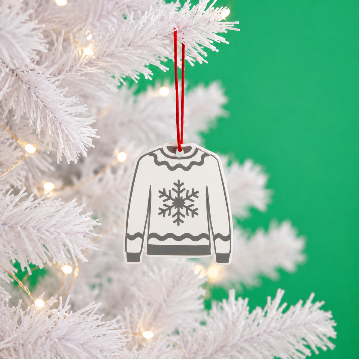 Snowflake Christmas jumper decoration hanging on a white tree