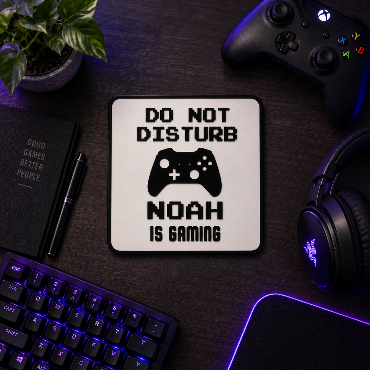 Personalised gaming sign reading NOAH IS GAMING laid flat on a desk with keyboard and headset